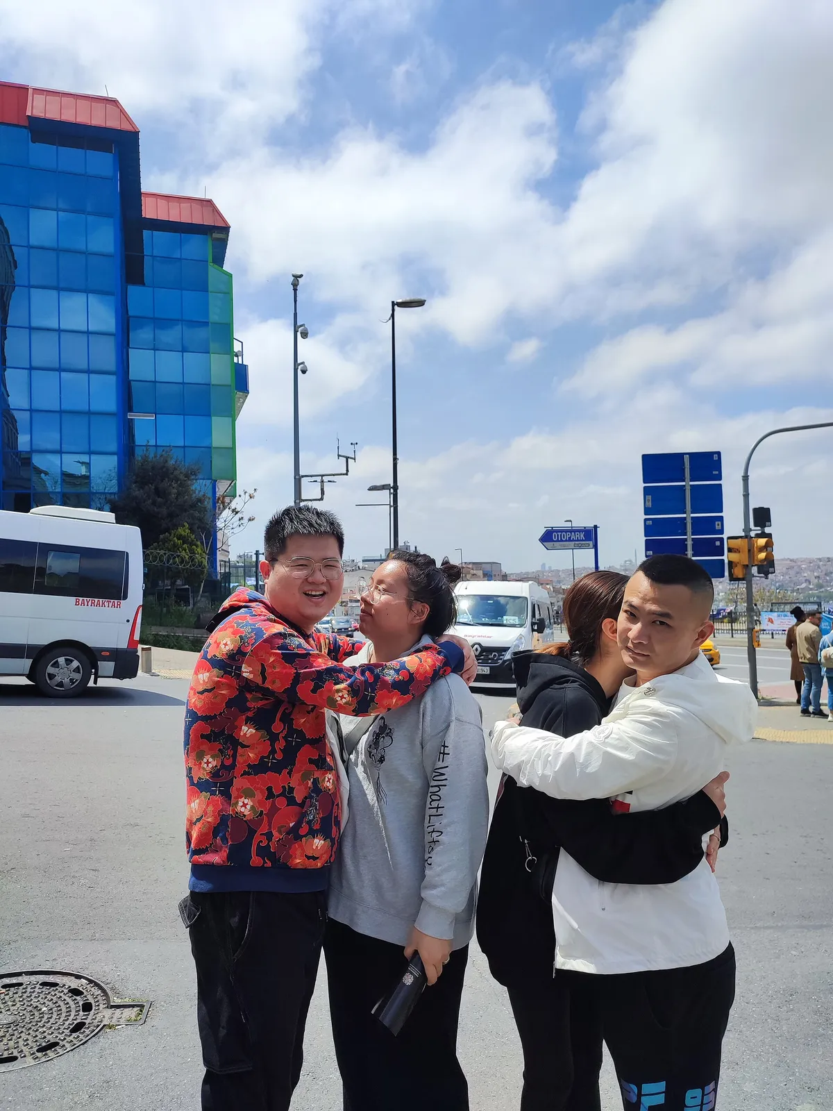 Grupo de amigos se abraçando em uma rua da cidade durante o dia