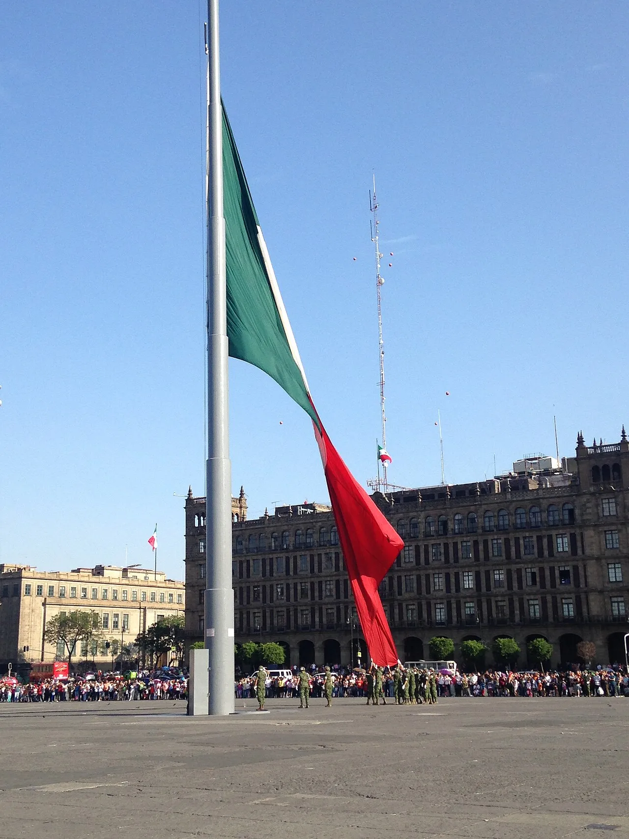 La bandera monumental de México ondeando en el Zócalo de la Ciudad de México, con Palacio Nacional al fondo
