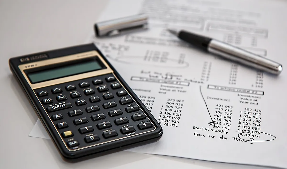 Calculadora sobre un documento financiero con notas escritas a mano