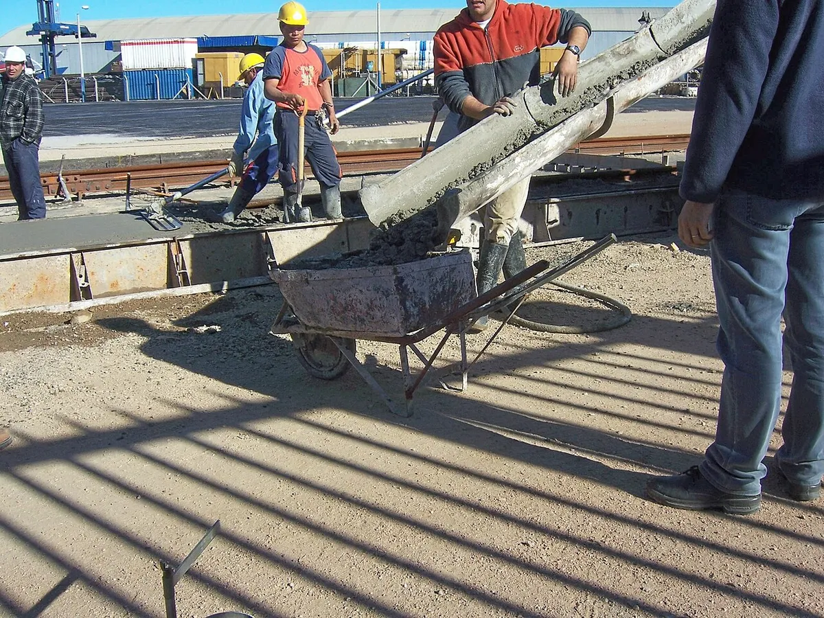 Trabajadores vertiendo concreto en una obra de vivienda