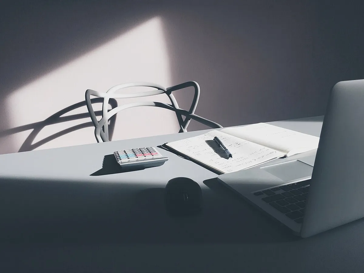 Escritorio con una laptop, una calculadora y documentos de trabajo