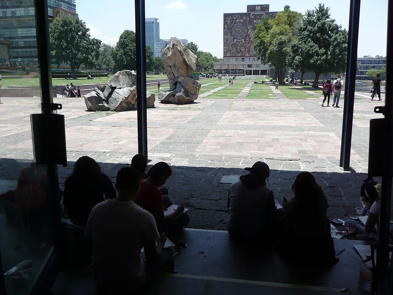 Estudiantes de Arquitectura dibujando una escultura con la Biblioteca Central al fondo en Ciudad Universitaria