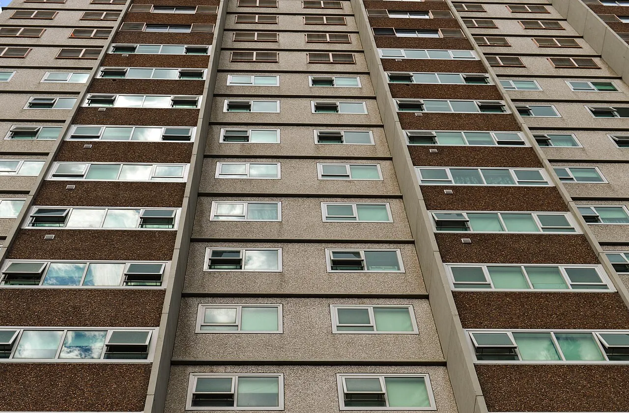 Vista hacia arriba de la fachada de un edificio residencial de muchos pisos