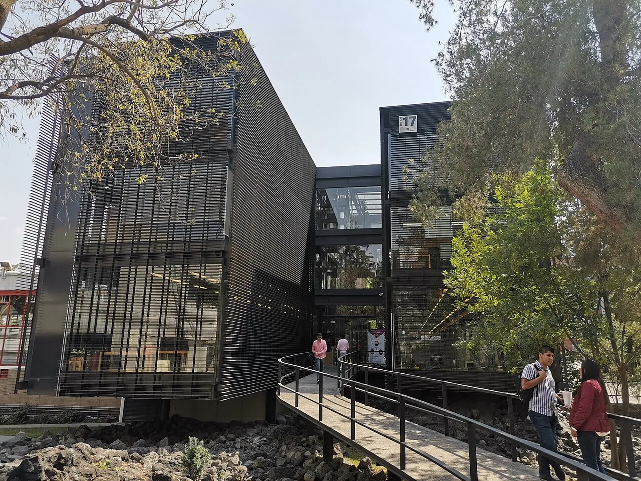 Edificio 17 de la Facultad de Ingeniería de la UNAM con estudiantes cruzando un puente peatonal