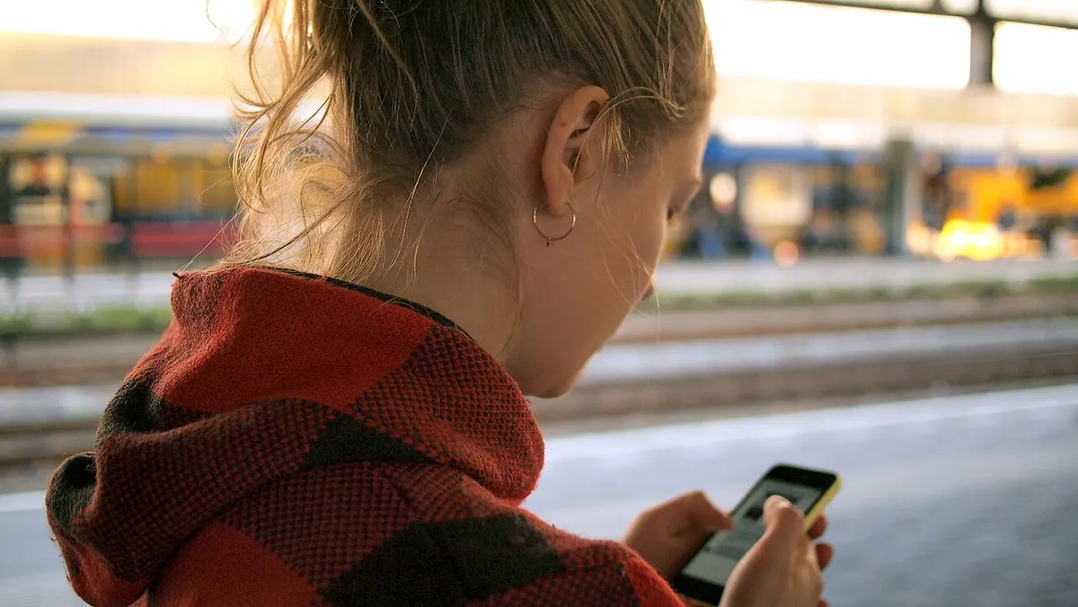 Joven revisando su celular en la calle