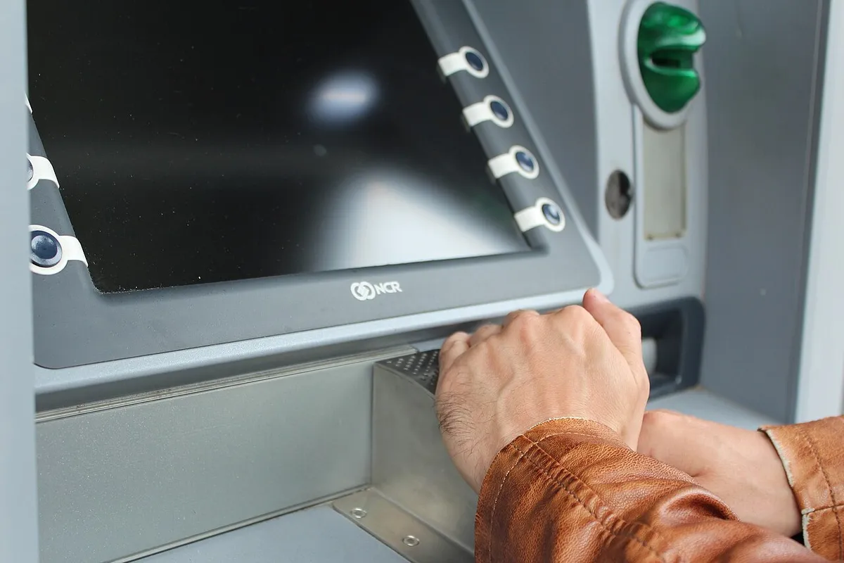 Una mano cubriendo el teclado de un cajero automático mientras introduce el NIP