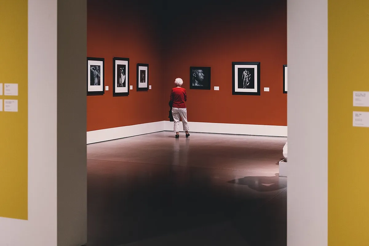 Una mujer adulta mayor contemplando una obra de arte en un museo