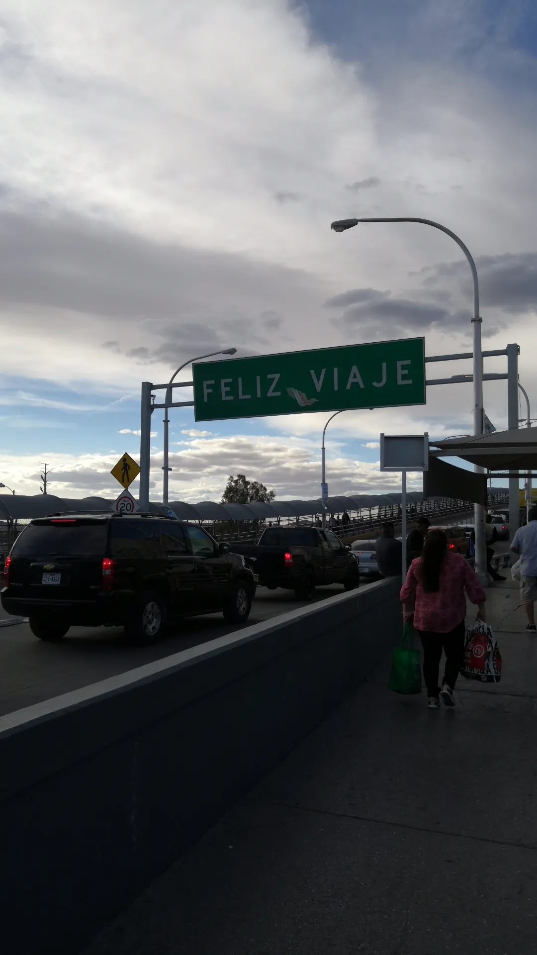 Personas con maletas cruzando a pie un puente internacional en Ciudad Juárez