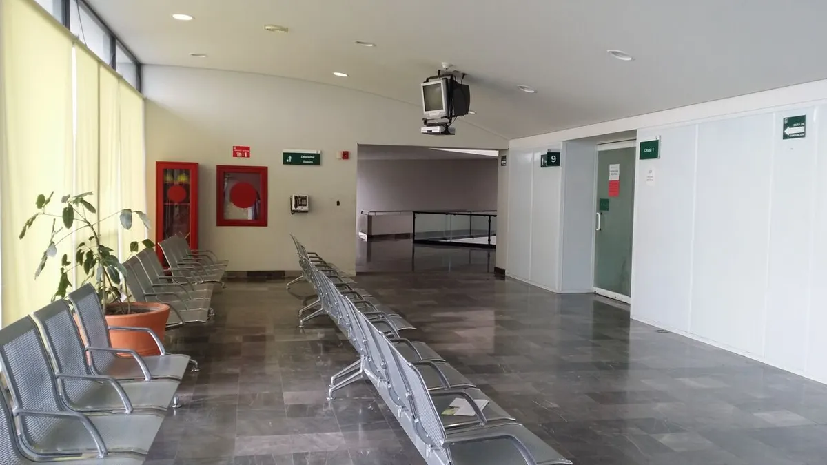 Sala de espera vacía de una unidad médica, con filas de asientos