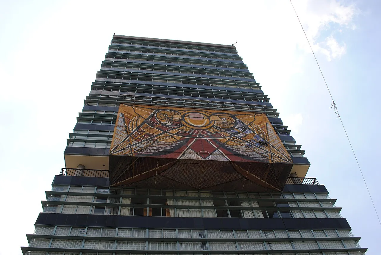Torre de Rectoría de la UNAM vista desde abajo con el mural de David Alfaro Siqueiros