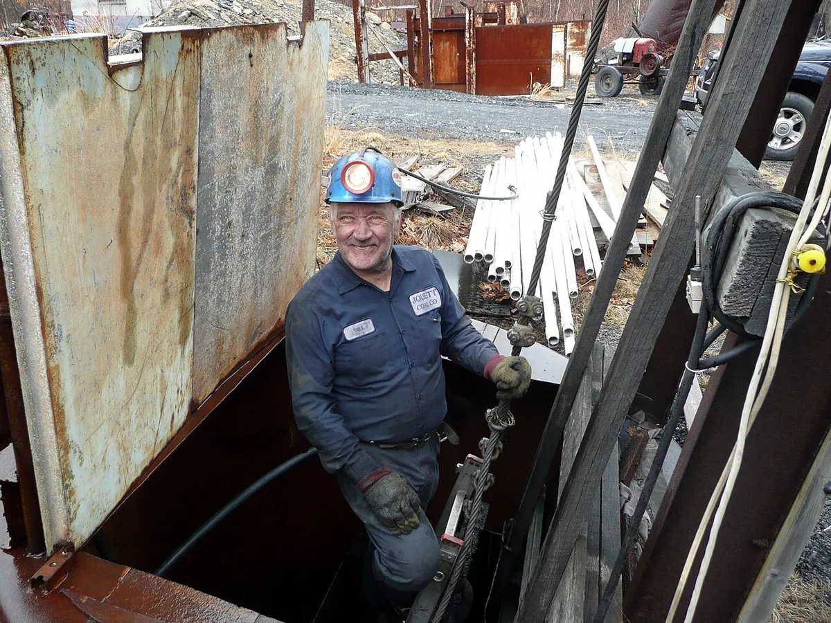 Trabajador mayor con casco sonriendo en el interior de una mina