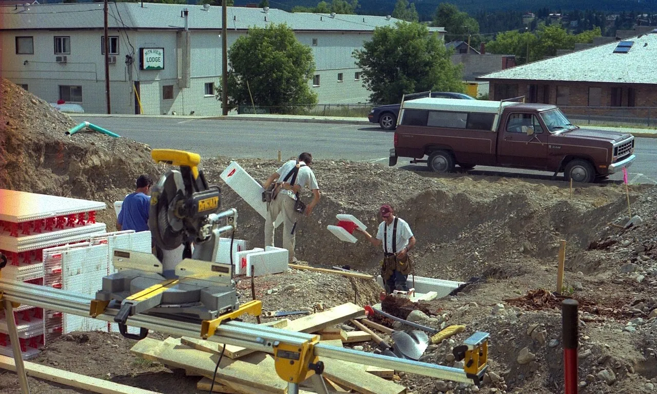 Trabajadores de la construcción levantando el armazón de madera de una vivienda