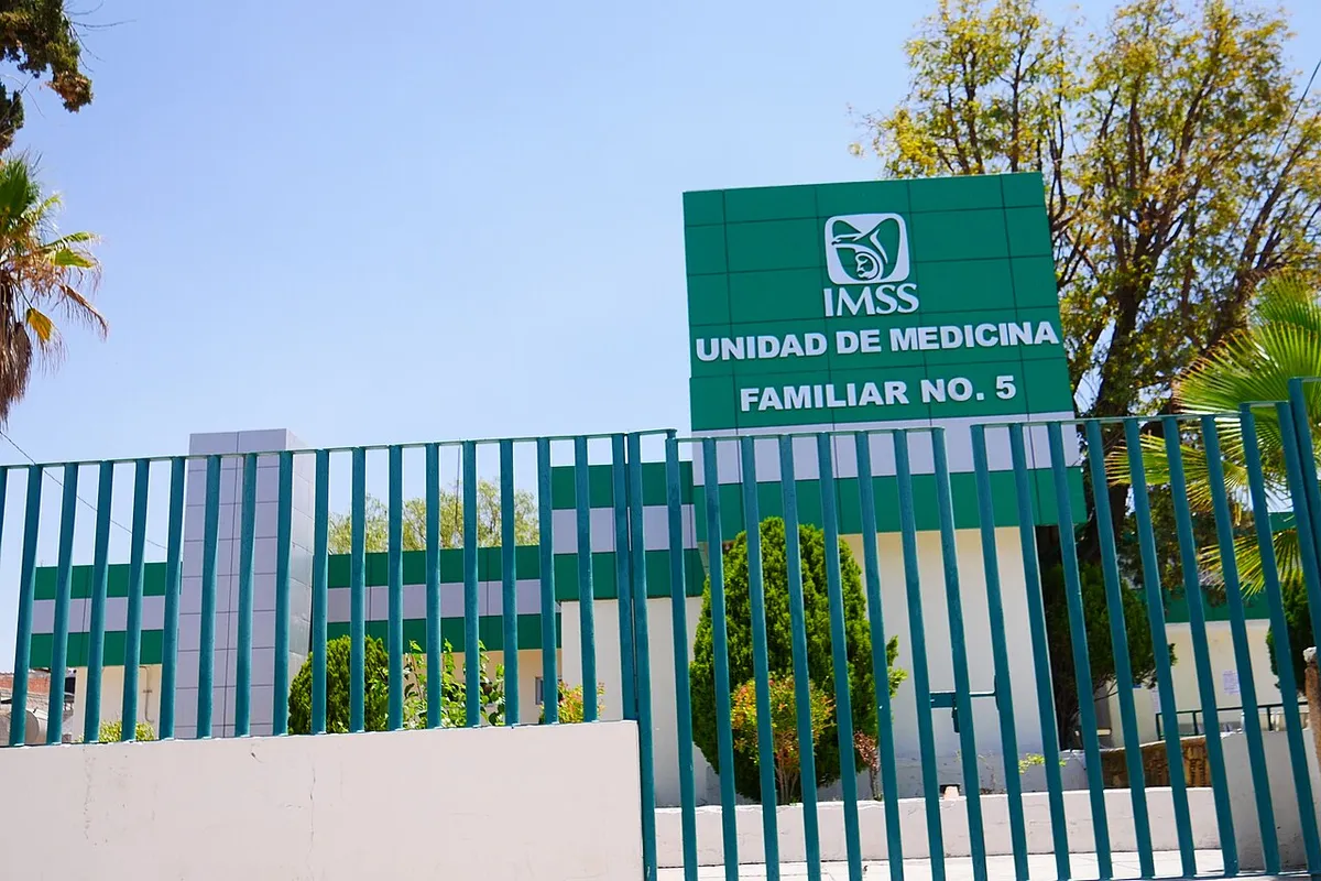 Letrero verde de la Unidad de Medicina Familiar No. 5 del IMSS, tras una reja