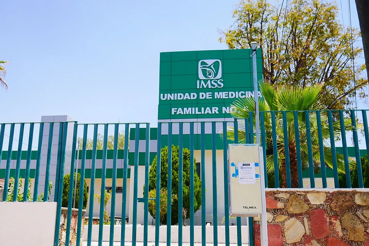 Letrero verde de una Unidad de Medicina Familiar del IMSS junto a su reja de acceso