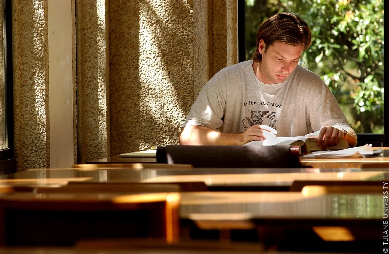 A student reading a book at a table in the Tulane University library, New Orleans